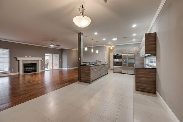 kitchen with crown molding, appliances with stainless steel finishes, modern cabinets, and dark countertops