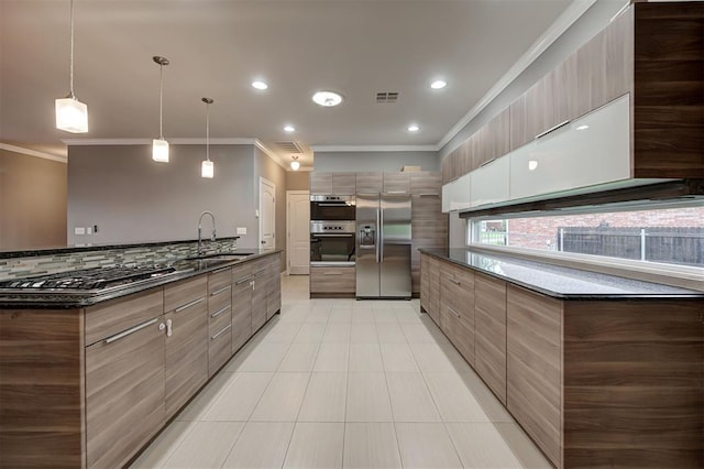 kitchen with crown molding, a sink, stainless steel appliances, visible vents, and modern cabinets