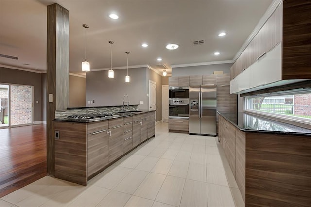 kitchen featuring appliances with stainless steel finishes, a sink, visible vents, ornamental molding, and modern cabinets