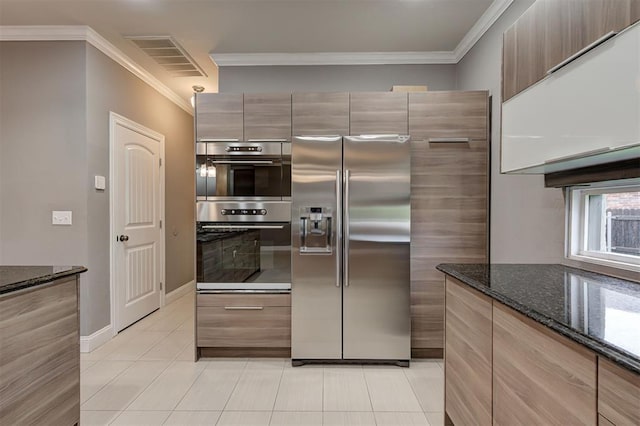 kitchen with light tile patterned flooring, appliances with stainless steel finishes, ornamental molding, and visible vents