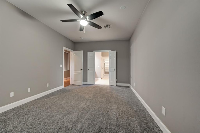 unfurnished bedroom featuring visible vents, baseboards, ceiling fan, carpet, and ensuite bath