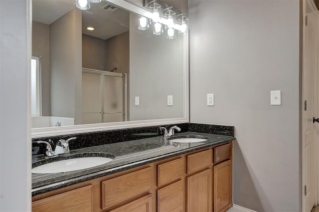 full bathroom featuring a sink, a stall shower, double vanity, and visible vents