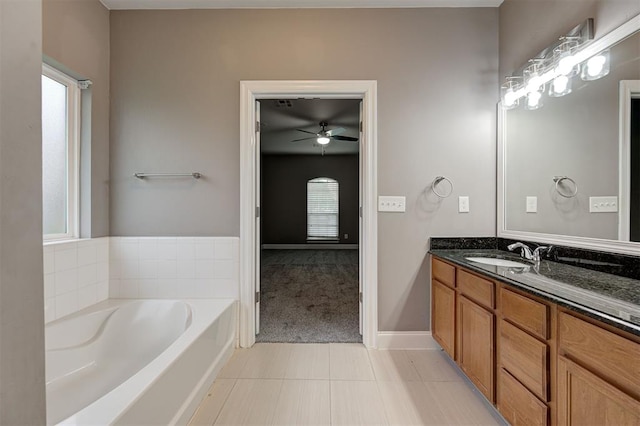 full bathroom with tile patterned flooring, a bath, a healthy amount of sunlight, and vanity