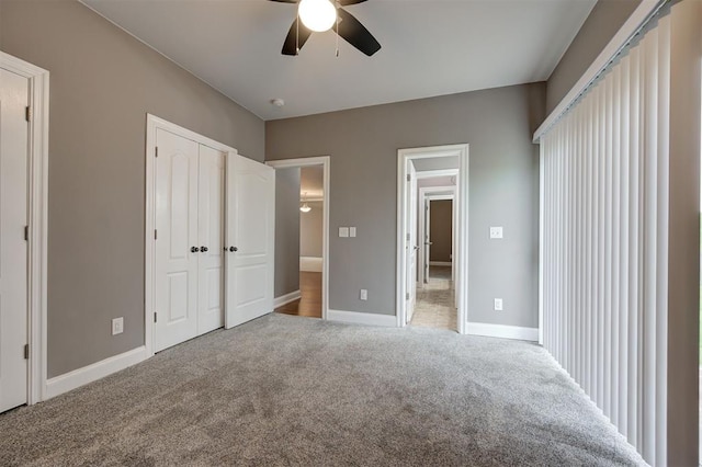 unfurnished bedroom featuring carpet floors, baseboards, and ceiling fan