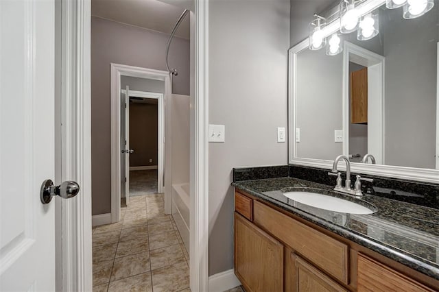 bathroom with baseboards, walk in shower, a tub to relax in, and vanity