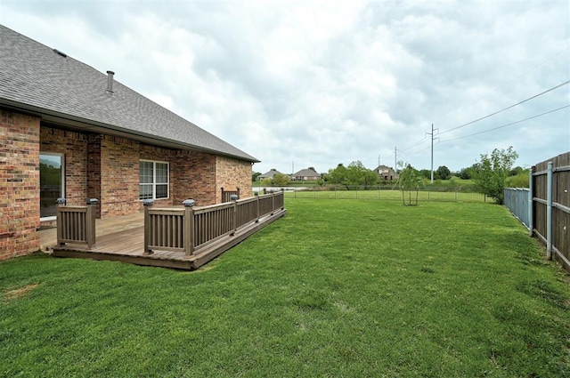 view of yard featuring fence and a deck