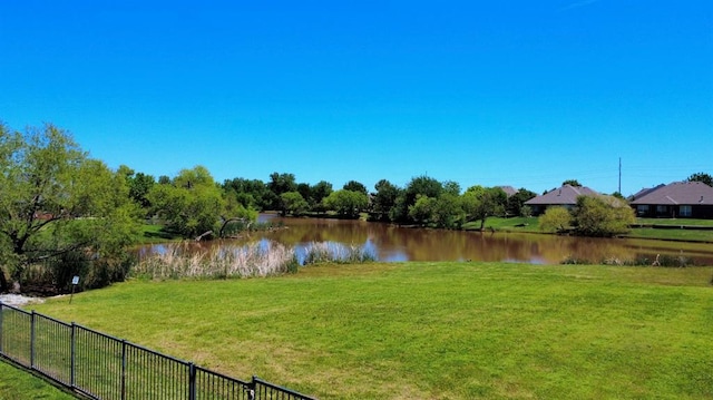view of yard featuring fence and a water view