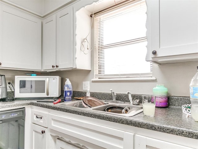 3205 S Madole Blvd, Oklahoma City, OK 73159 - kitchen featuring dishwashing machine, white microwave, a sink, and white cabinets