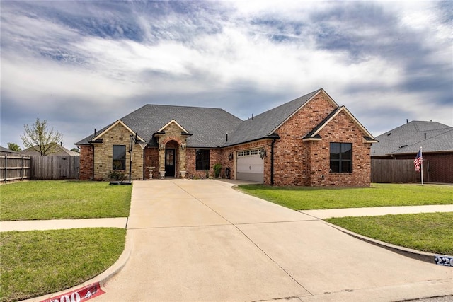 view of front of home with driveway, a garage, fence, and a front lawn