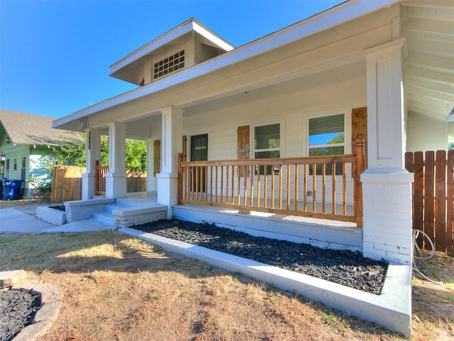 view of front facade featuring fence and covered porch
