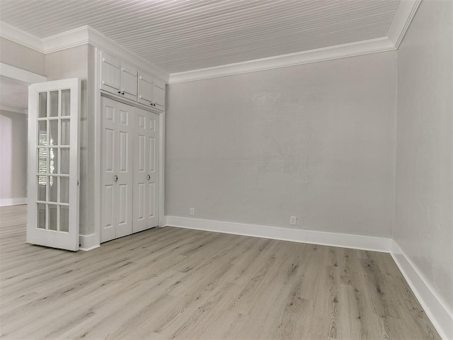 unfurnished bedroom featuring crown molding, a closet, baseboards, and light wood-type flooring