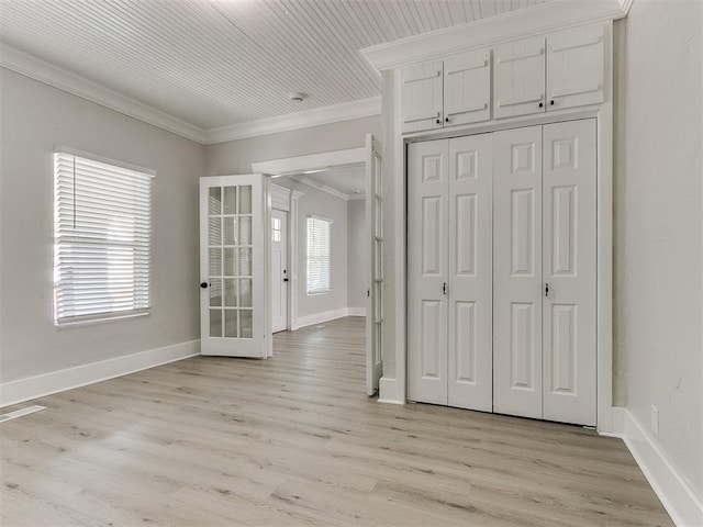 interior space with ornamental molding, baseboards, light wood-type flooring, and a closet