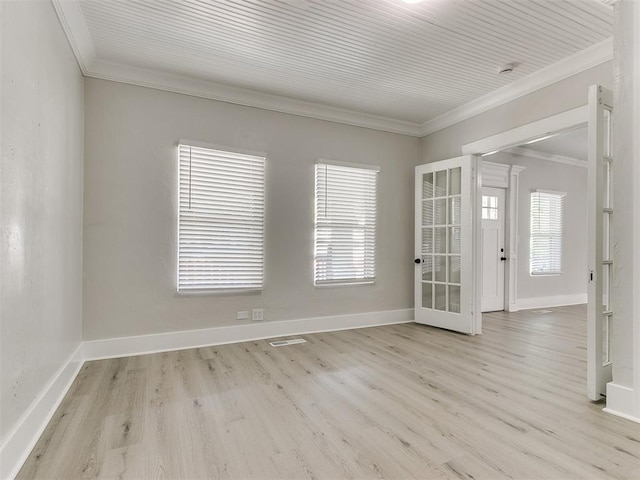 empty room with ornamental molding, baseboards, and wood finished floors