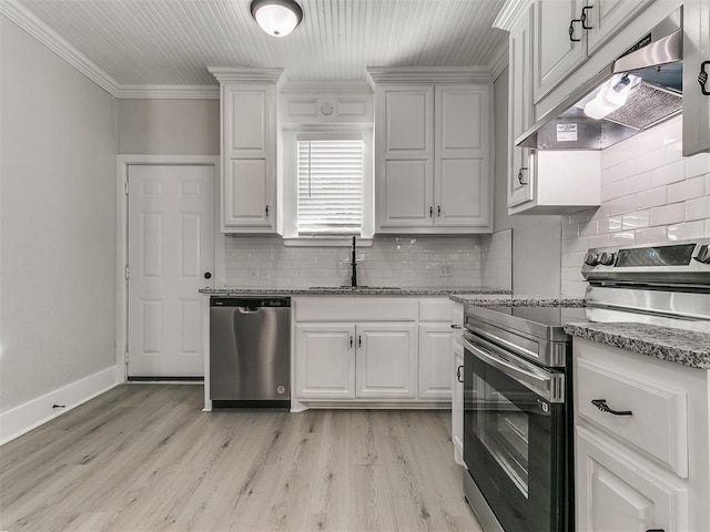 kitchen with ornamental molding, appliances with stainless steel finishes, under cabinet range hood, a sink, and backsplash