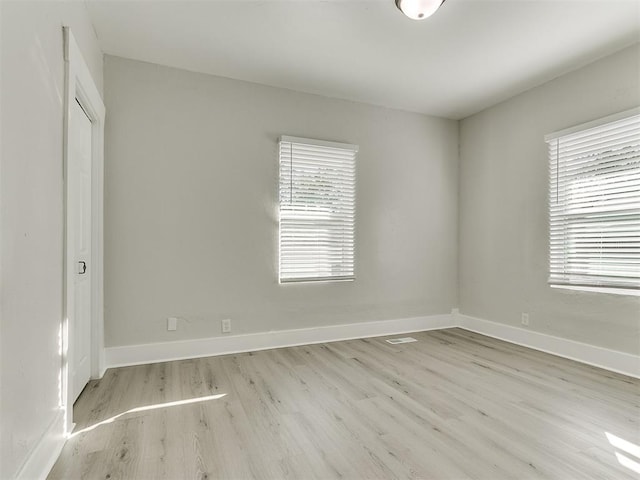 empty room featuring wood finished floors and baseboards