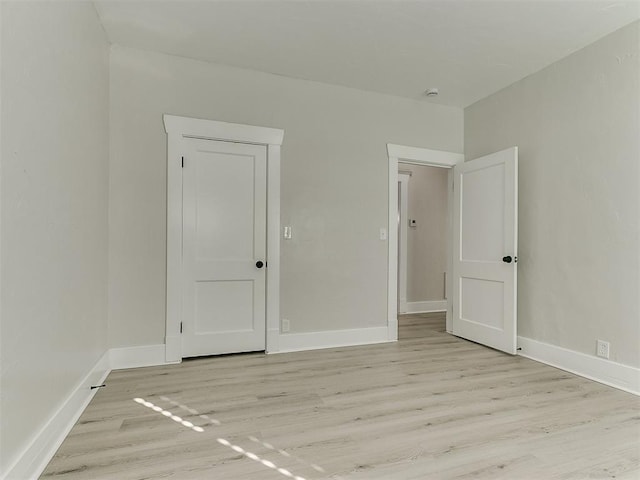 empty room featuring light wood-style floors and baseboards