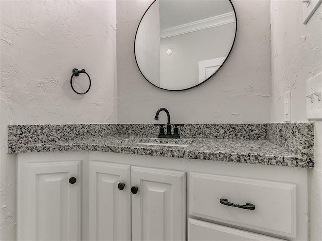 bathroom featuring vanity and a textured wall