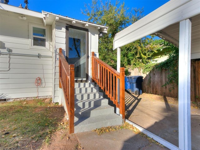 doorway to property featuring fence and a patio