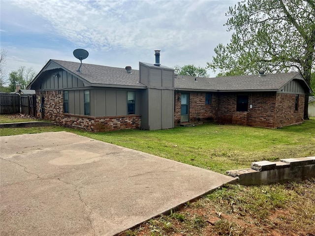136 Skyline Dr, Chickasha, OK 73018 - rear view of house featuring a yard, brick siding, and board and batten siding
