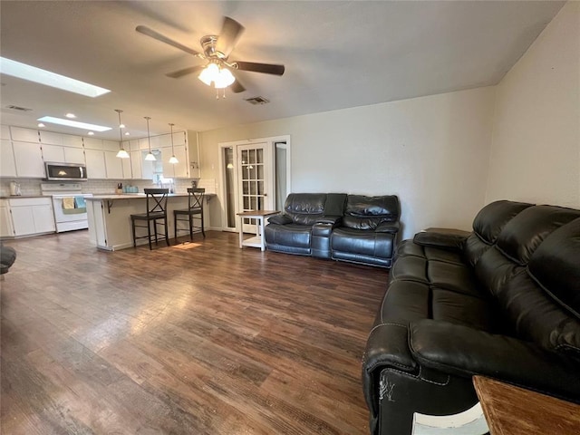 136 Skyline Dr, Chickasha, OK 73018 - living area featuring visible vents, a skylight, a ceiling fan, and dark wood-style floors
