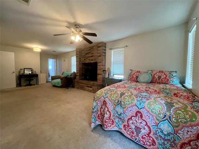 136 Skyline Dr, Chickasha, OK 73018 - bedroom featuring a fireplace, carpet, multiple windows, and a ceiling fan