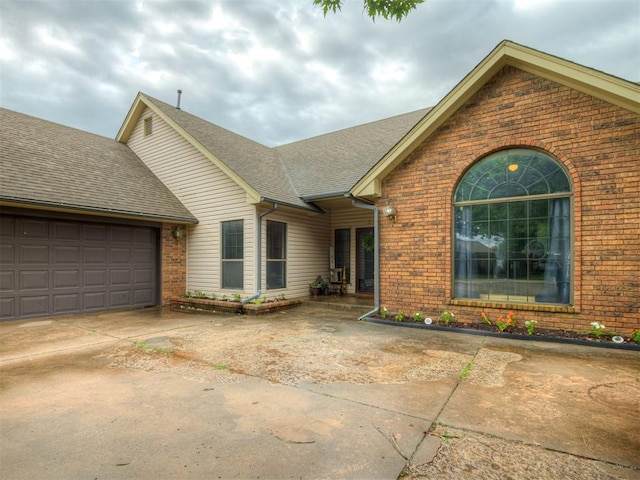 7 Kaross Dr, Shawnee, OK 74801 - ranch-style house featuring brick siding, a garage, driveway, and a shingled roof