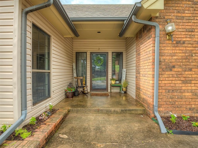 7 Kaross Dr, Shawnee, OK 74801 - view of exterior entry featuring roof with shingles and brick siding