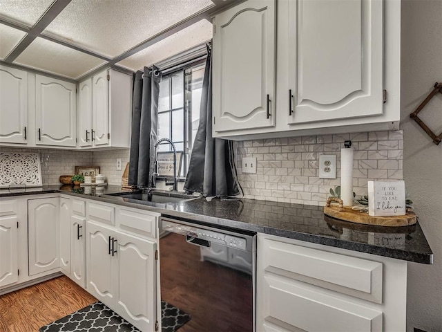 7 Kaross Dr, Shawnee, OK 74801 - kitchen featuring black dishwasher, dark countertops, tasteful backsplash, light wood-style flooring, and white cabinets