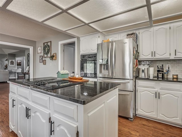 7 Kaross Dr, Shawnee, OK 74801 - kitchen with black appliances, decorative backsplash, white cabinets, and a center island