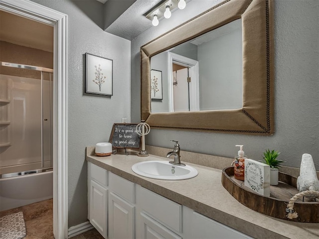 7 Kaross Dr, Shawnee, OK 74801 - bathroom featuring a textured wall, vanity, and shower / bath combination with glass door