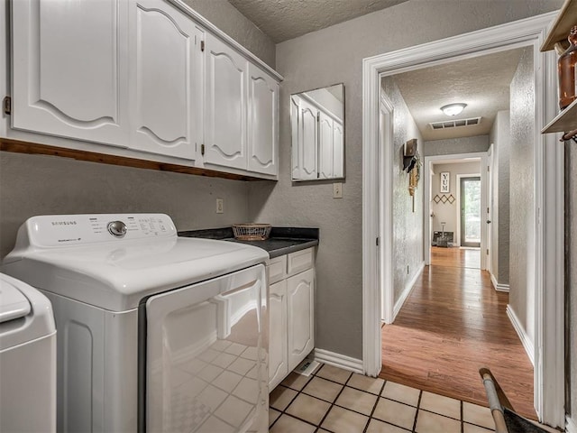 7 Kaross Dr, Shawnee, OK 74801 - washroom with a textured ceiling, cabinet space, a textured wall, and light tile patterned floors