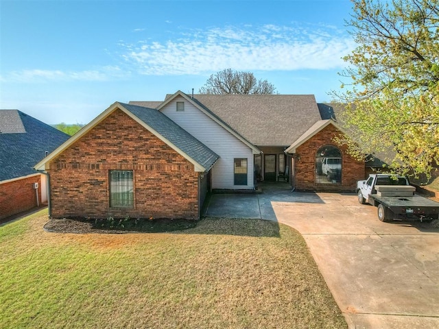 7 Kaross Dr, Shawnee, OK 74801 - view of front of home featuring brick siding, a front lawn, and roof with shingles