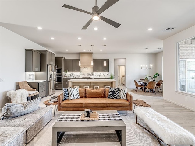 living area featuring recessed lighting, light wood-style flooring, baseboards, and visible vents