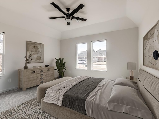 bedroom featuring baseboards, multiple windows, light colored carpet, and a ceiling fan