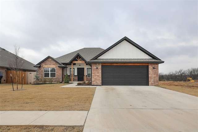 craftsman-style house featuring a garage, a front yard, concrete driveway, and brick siding