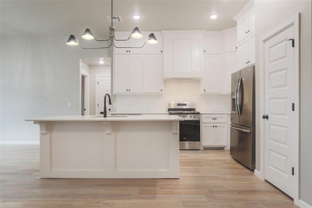 kitchen with white cabinets, light countertops, a sink, and appliances with stainless steel finishes