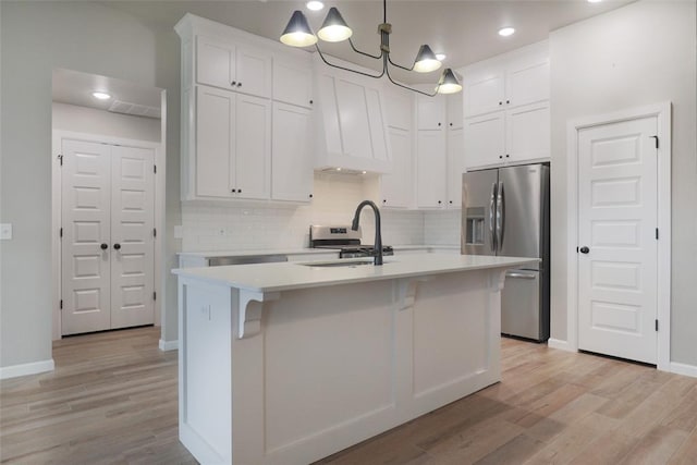 kitchen featuring a sink, light countertops, appliances with stainless steel finishes, and light wood-style floors
