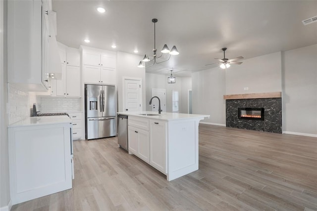 kitchen with white cabinetry, light countertops, appliances with stainless steel finishes, and a ceiling fan
