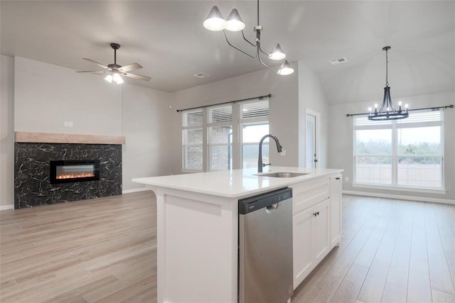 kitchen featuring open floor plan, dishwasher, a sink, and light wood finished floors