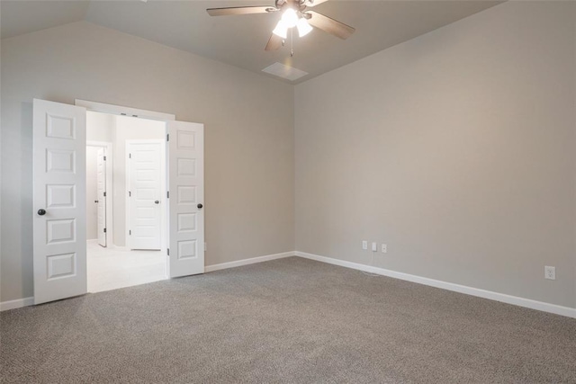 carpeted empty room with baseboards, vaulted ceiling, and ceiling fan