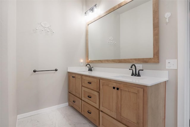 bathroom featuring baseboards, double vanity, marble finish floor, and a sink