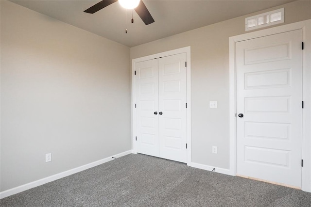 unfurnished bedroom featuring a closet, baseboards, a ceiling fan, visible vents, and carpet