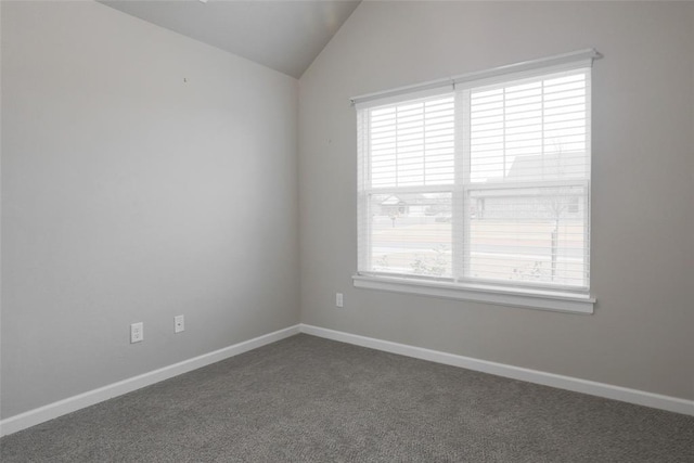 empty room with baseboards, dark carpet, and lofted ceiling