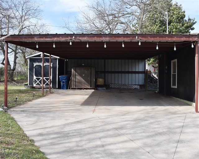 garage featuring a carport, driveway, and a shed