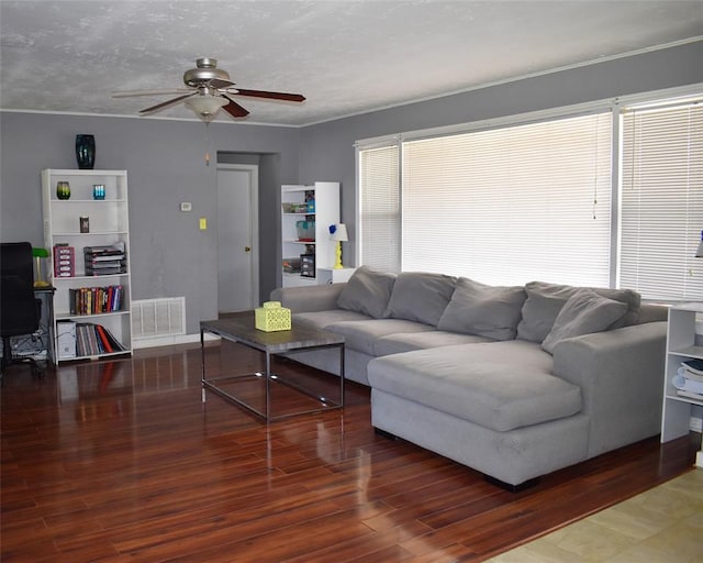 living room with visible vents, a ceiling fan, and wood finished floors