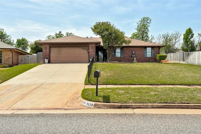1113 Bank Side Cir, Edmond, OK 73012 - ranch-style house featuring a garage, concrete driveway, fence, a front yard, and brick siding