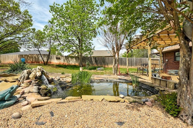 1113 Bank Side Cir, Edmond, OK 73012 - view of yard with a pergola, a fenced backyard, and a garden pond