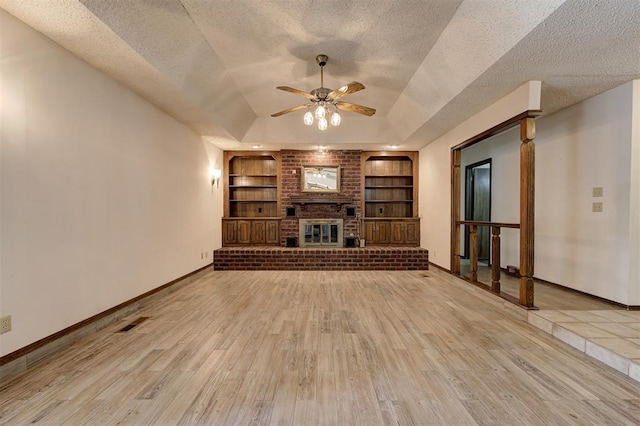 1113 Bank Side Cir, Edmond, OK 73012 - unfurnished living room with wood finished floors, built in features, baseboards, and ceiling fan