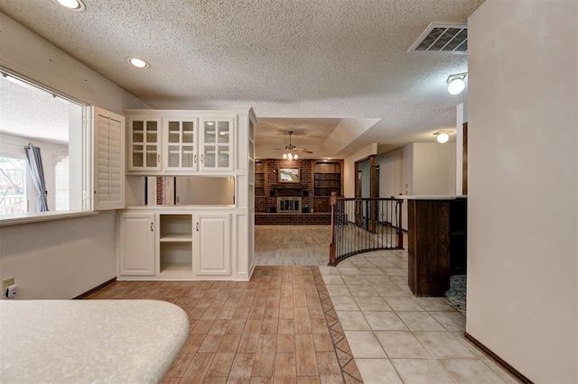 1113 Bank Side Cir, Edmond, OK 73012 - interior space with a textured ceiling, baseboards, visible vents, recessed lighting, and a brick fireplace