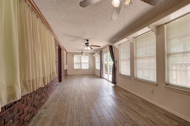 1113 Bank Side Cir, Edmond, OK 73012 - unfurnished living room with baseboards, a ceiling fan, wood finished floors, and a textured ceiling